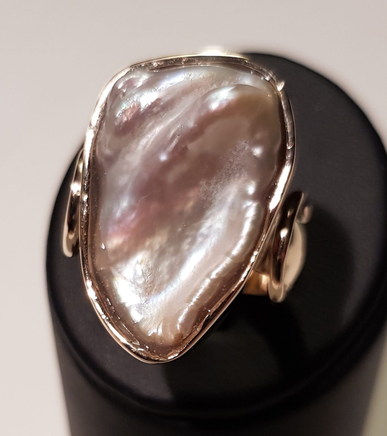 Goldring mit großer, schillernder, perlmuttfarbener lavendelfarbener Perle.
