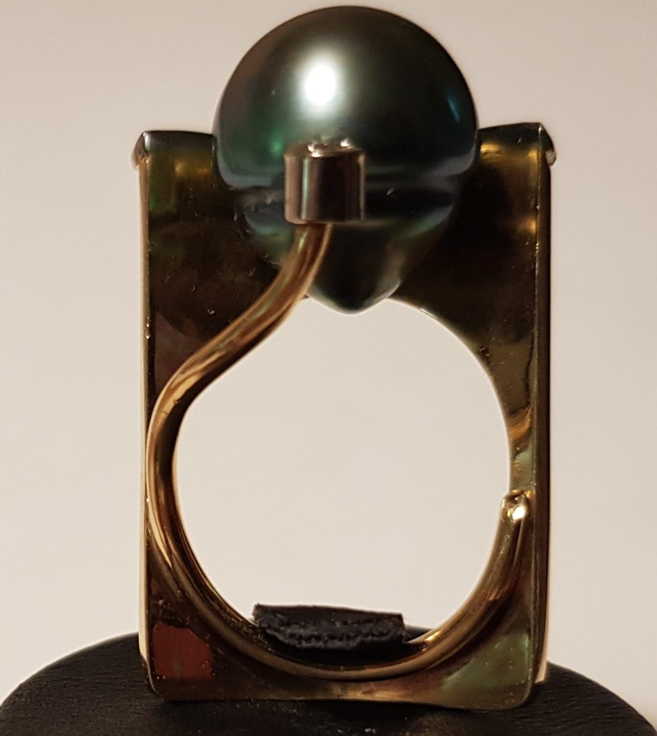 Goldring mit großer, dunkler Perle.