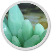 Piedras cristalinas de color verde menta en un marco circular.