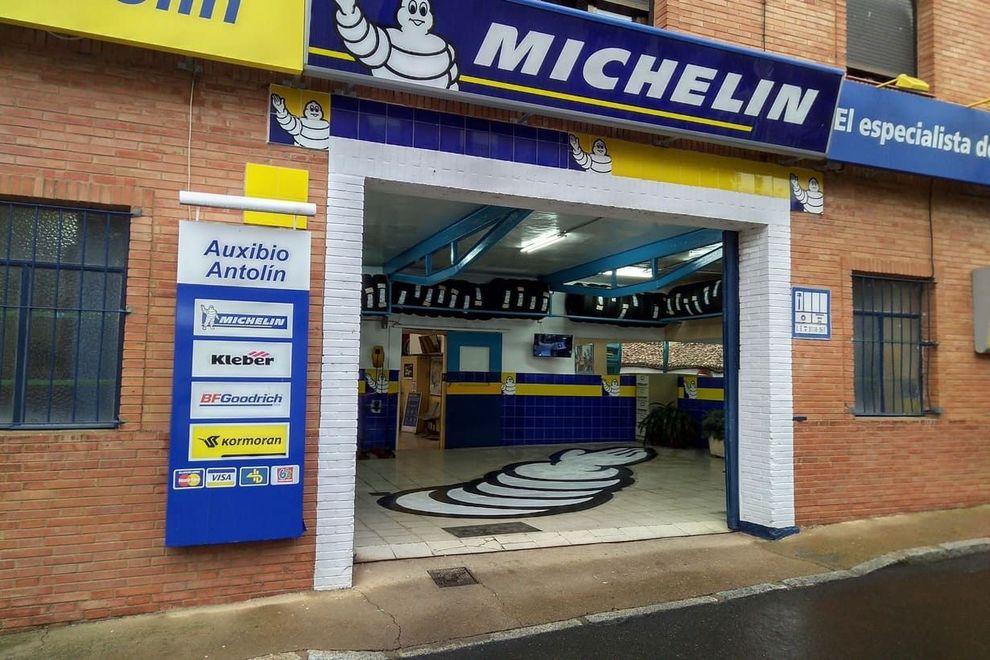 Una tienda de neumáticos Michelin está ubicada en un edificio de ladrillo.