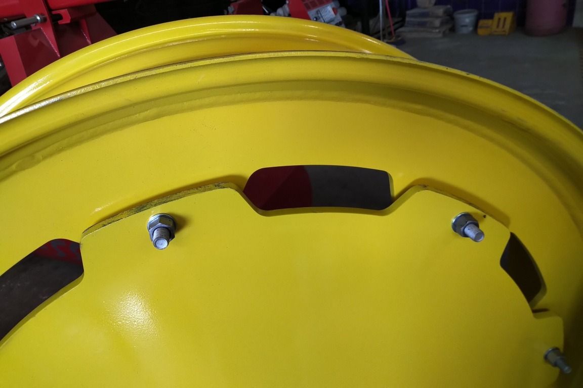 Un primer plano de una rueda amarilla en un tractor.