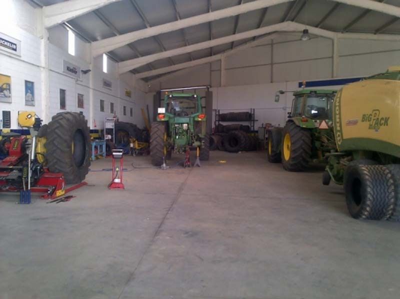 Un tractor John Deere está estacionado en un garaje.
