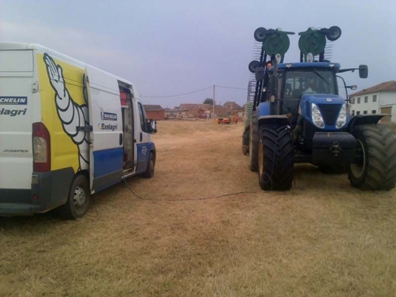 Un tractor está estacionado junto a una furgoneta Michelin.