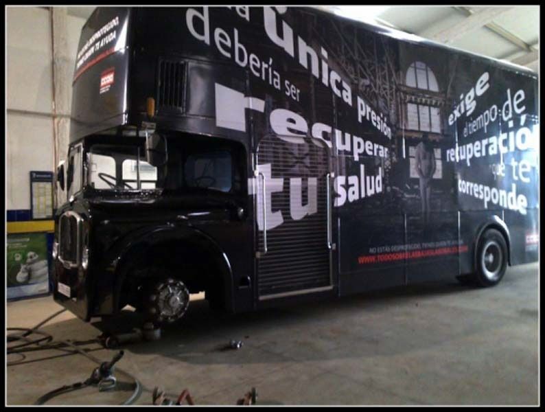 Un autobús negro de dos pisos con escritura en español.