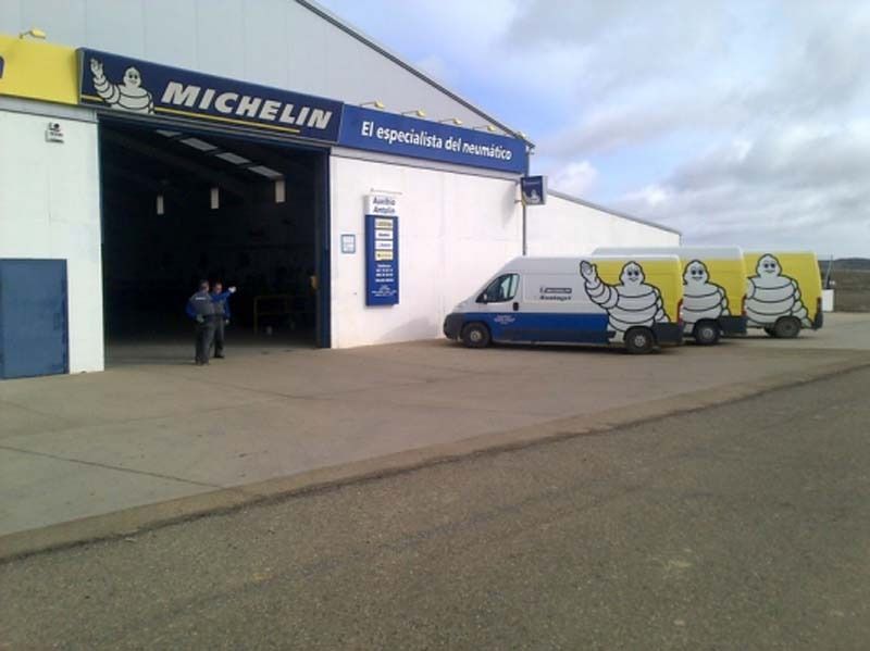 Dos furgonetas Michelin están aparcadas delante de un edificio.