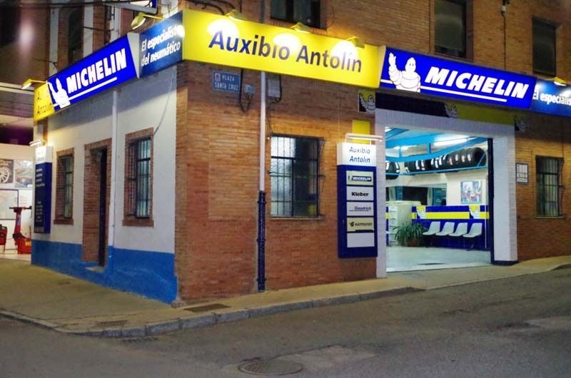 Una tienda de neumáticos Michelin está en la esquina de un edificio de ladrillos.