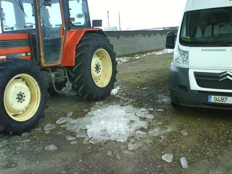 Un tractor está estacionado junto a una furgoneta Citroën.