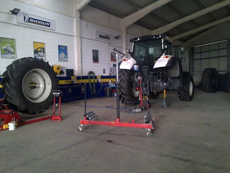 Se está trabajando en un tractor en un taller de neumáticos.