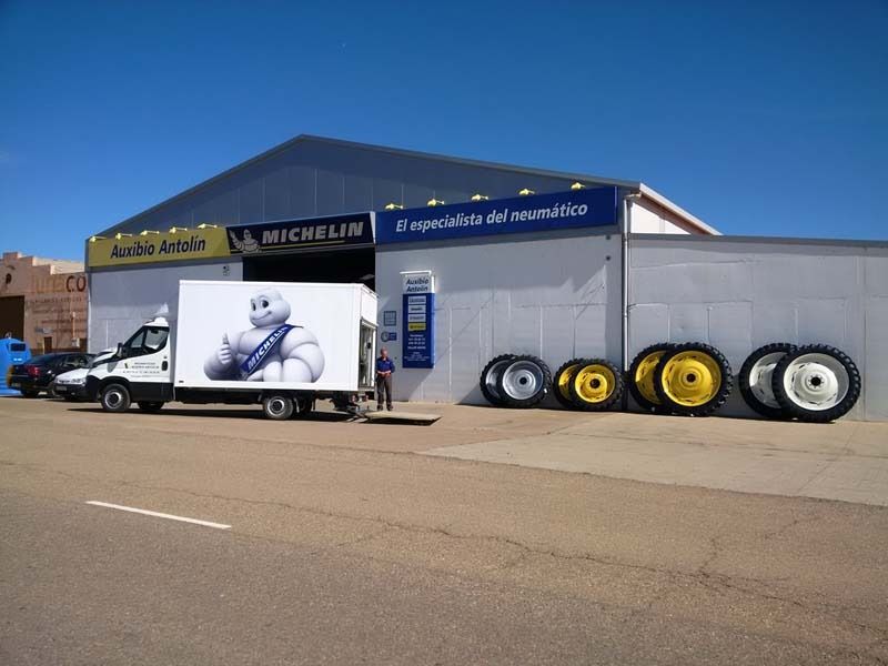 Un camión Michelin está estacionado frente a un edificio.