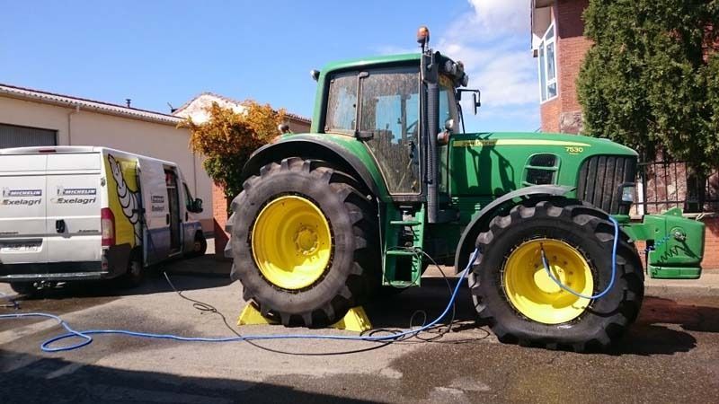 Un tractor John Deere verde está estacionado en un estacionamiento.