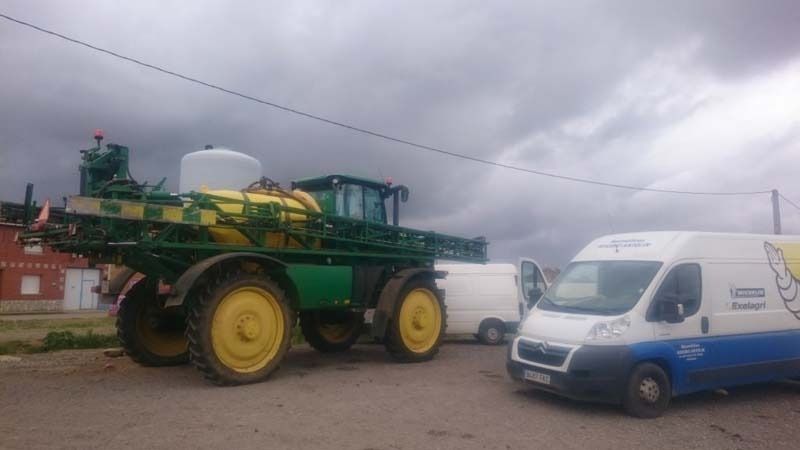 Un tractor está estacionado al lado de una camioneta en un estacionamiento.