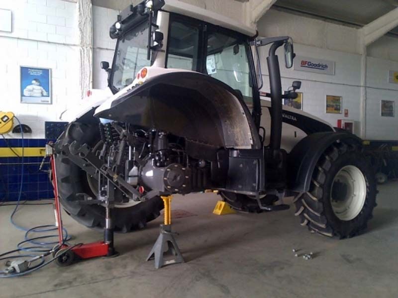 Se está trabajando en un tractor en un garaje.