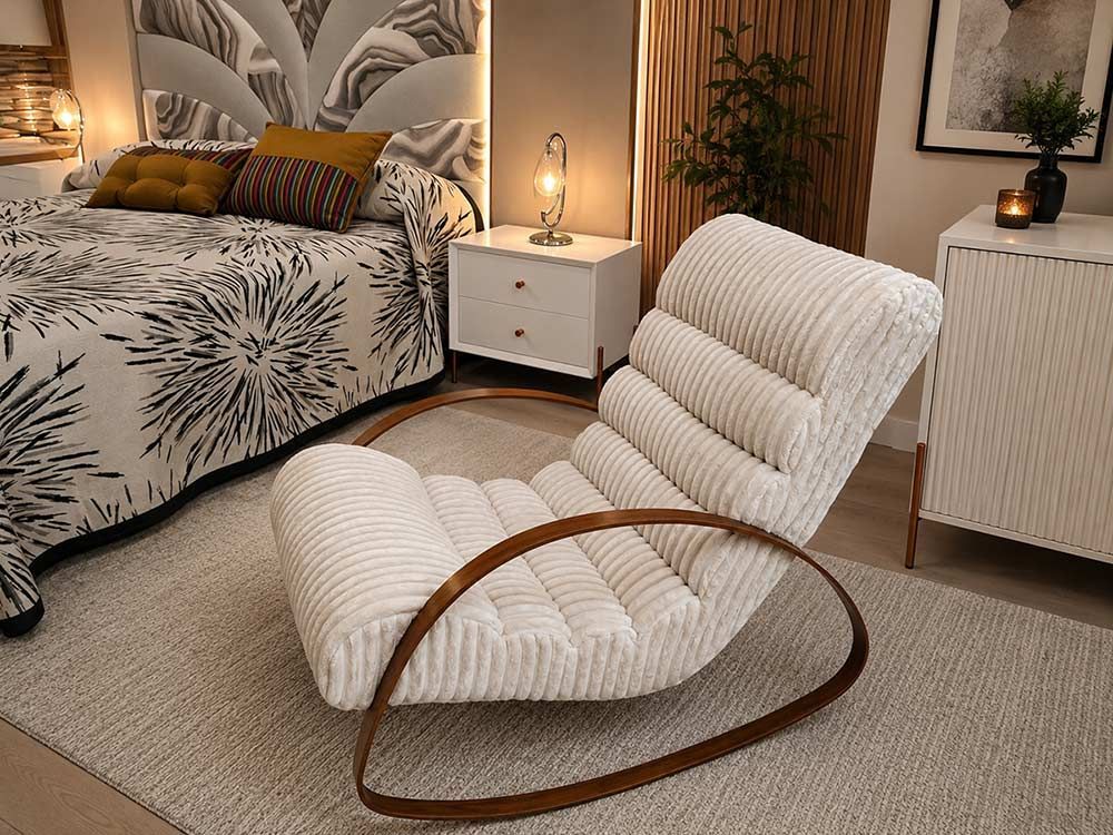 Sillón curvo blanco con base de madera en un acogedor dormitorio junto a la cama y la mesita de noche.