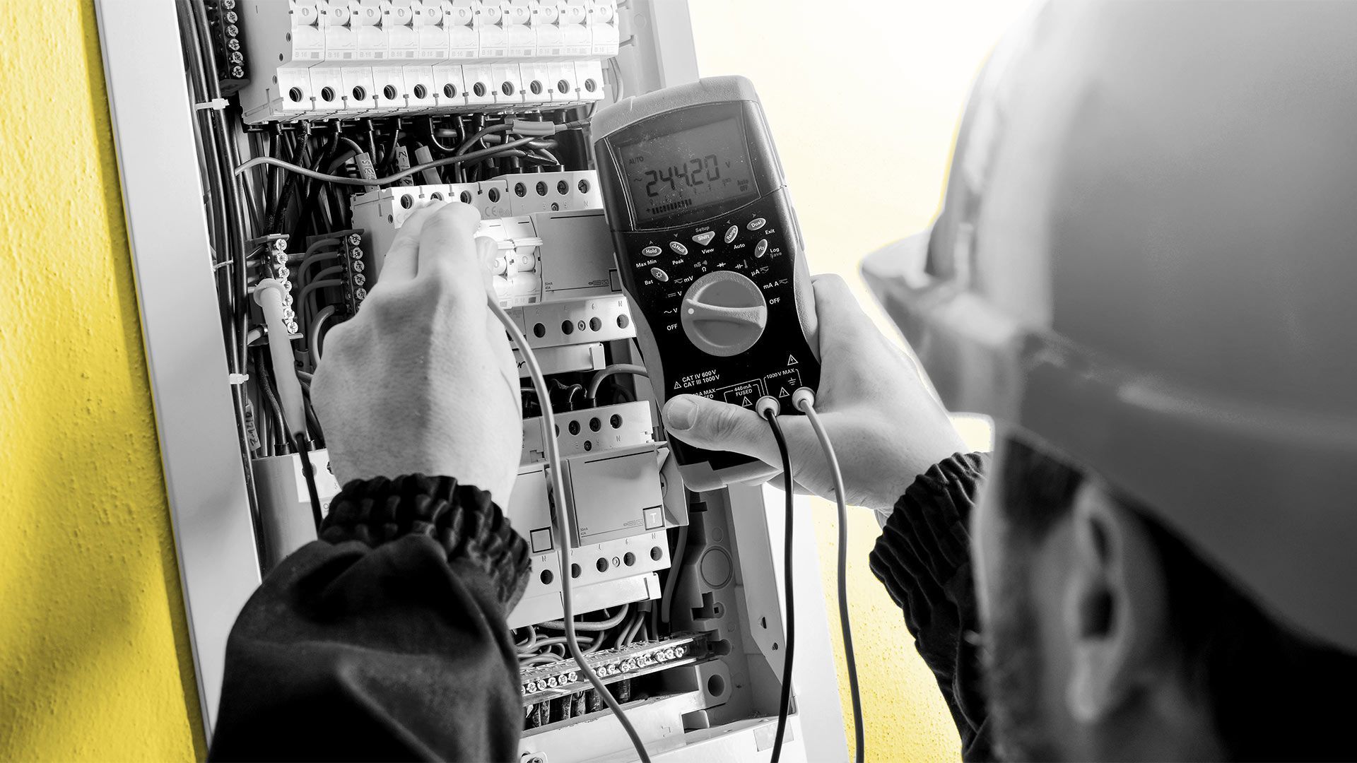 Focus sur un électricien testant des voltages dans un disjoncteur