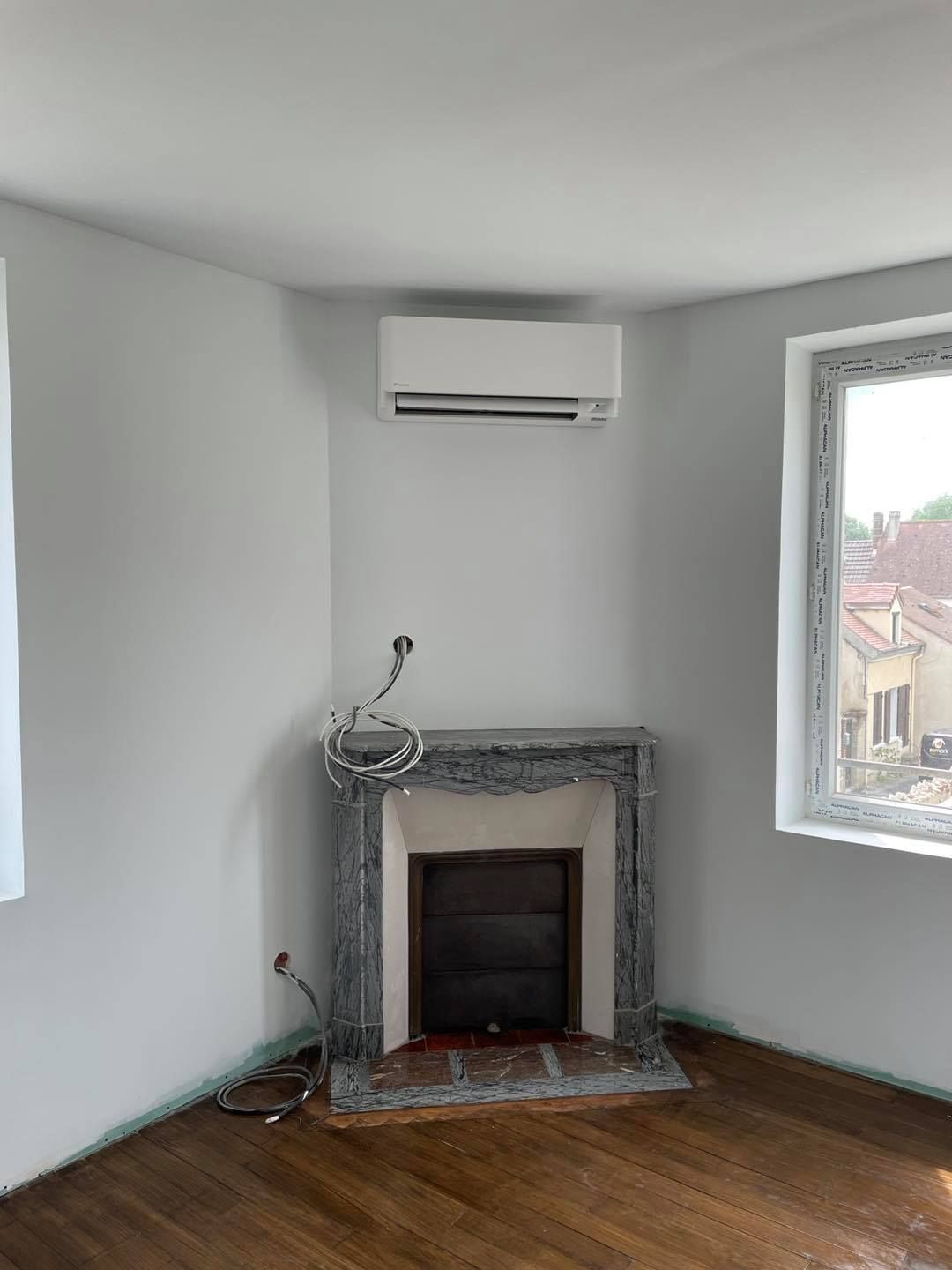 Climatiseur monosplit placé au-dessus d'une cheminée