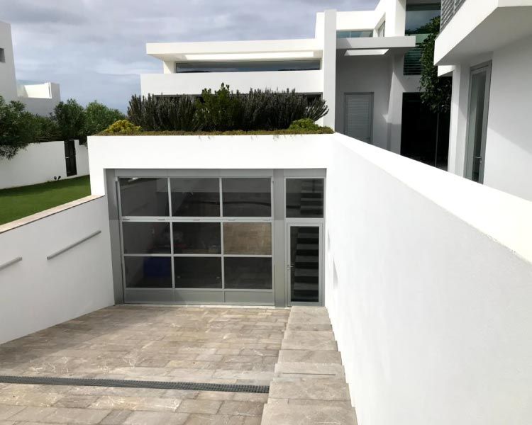 Una casa blanca con un garaje debajo.