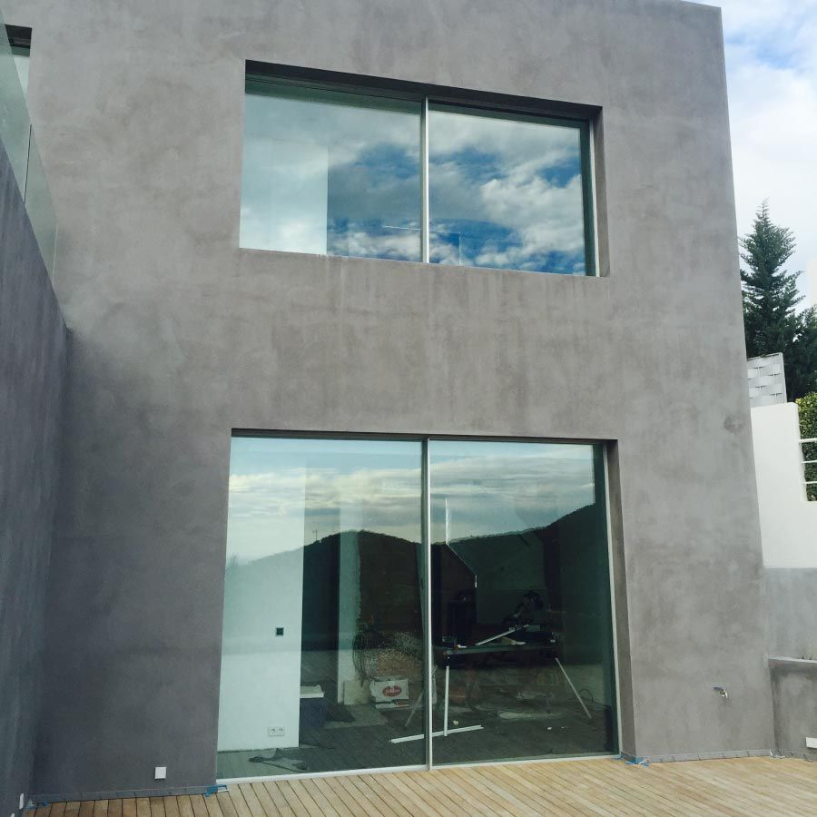 Un edificio con muchas ventanas y una terraza de madera.