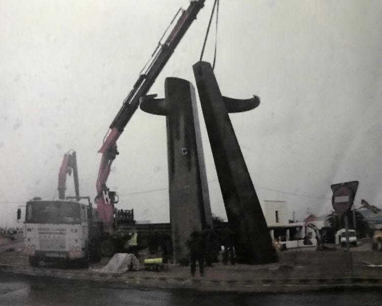Una fotografía en blanco y negro de una grúa levantando una estatua.