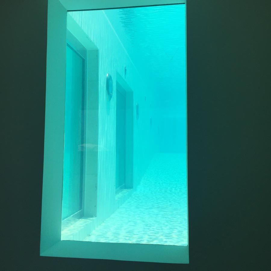 Una vista de una piscina a través de una ventana de un edificio.