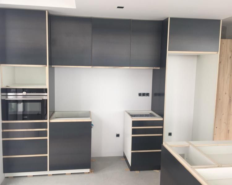 Una cocina con gabinetes negros y un horno de estufa.