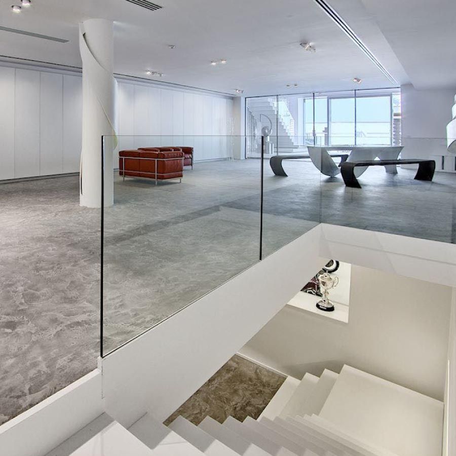 Escaleras que conducen a una habitación con barandilla de cristal.