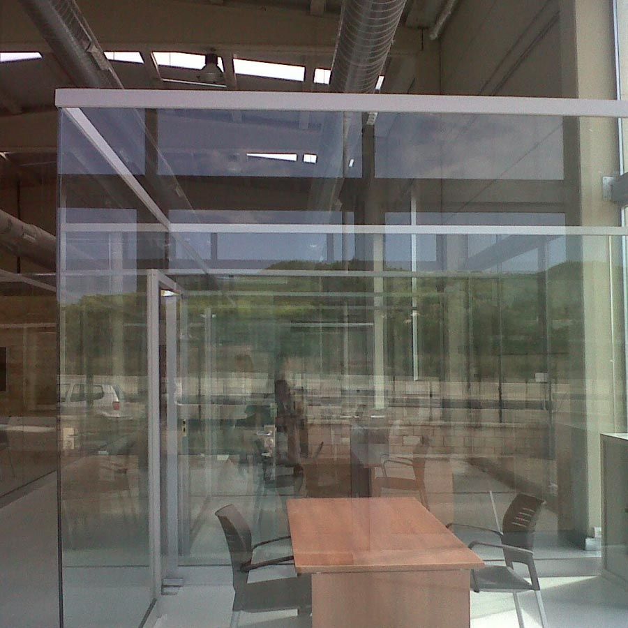 Una habitación de cristal con una mesa y sillas dentro.