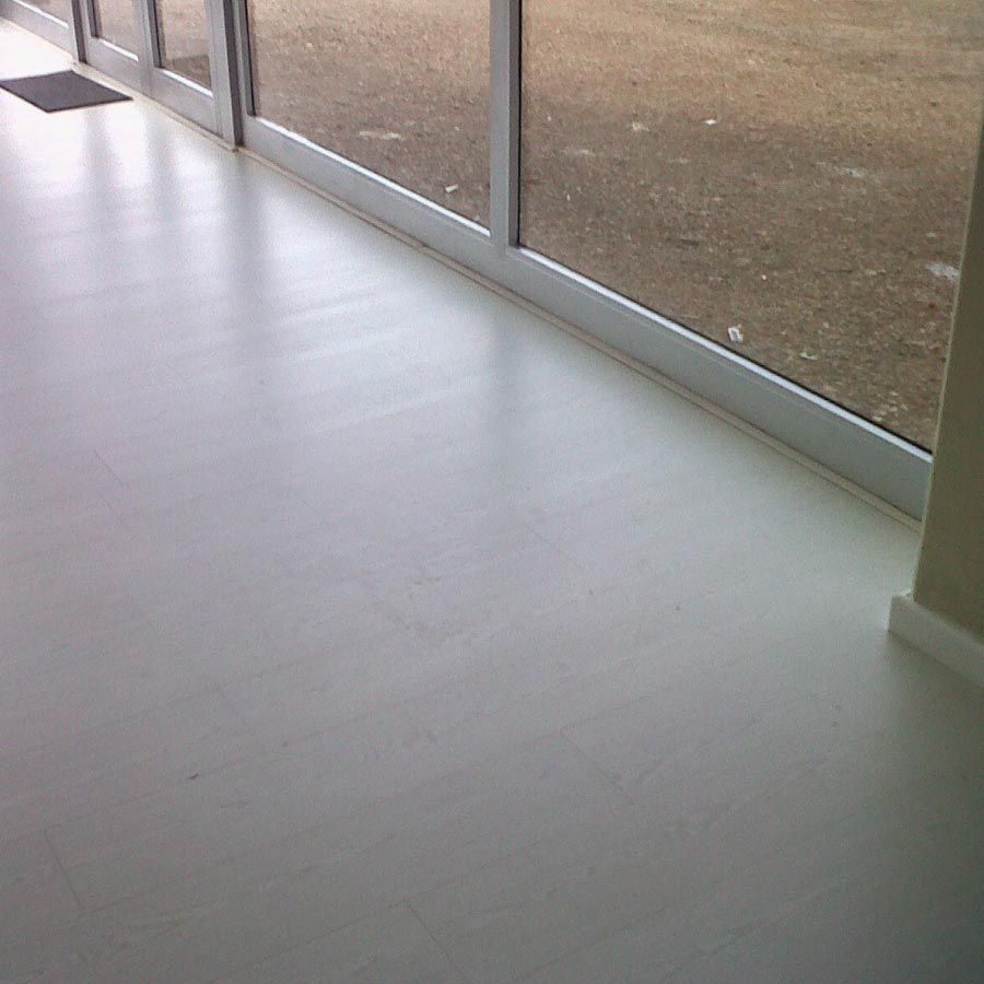 Un piso blanco con una puerta corrediza de vidrio al fondo.