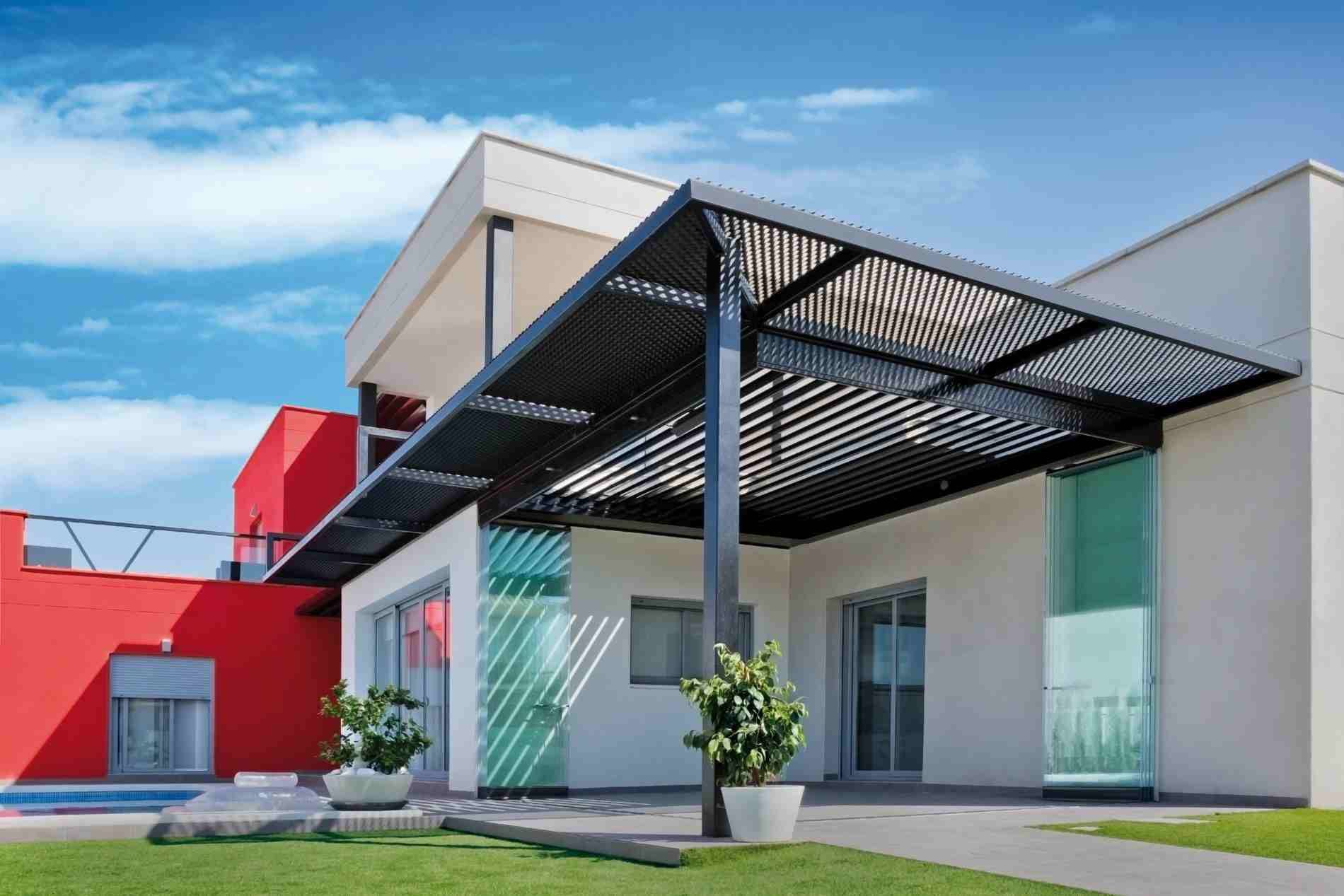 Una casa blanca con techo rojo y pérgola negra