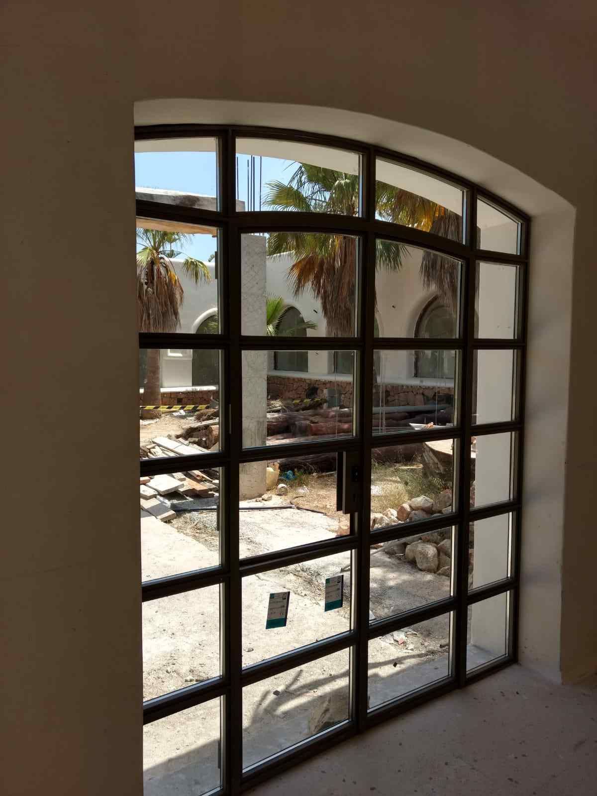 Una habitación con una gran ventana y vista a un edificio en construcción.