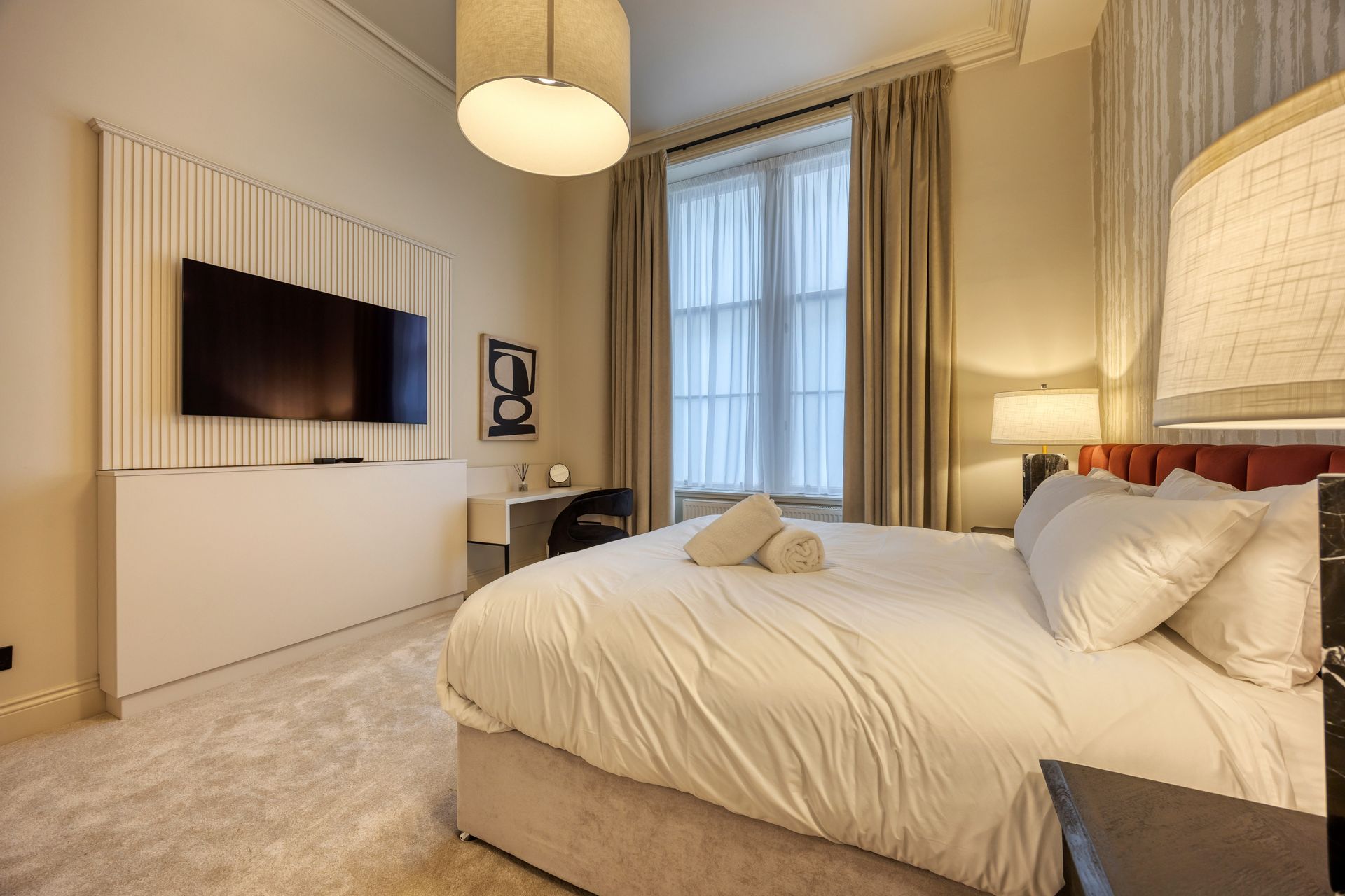 A hotel room with a king size bed and a flat screen tv.
