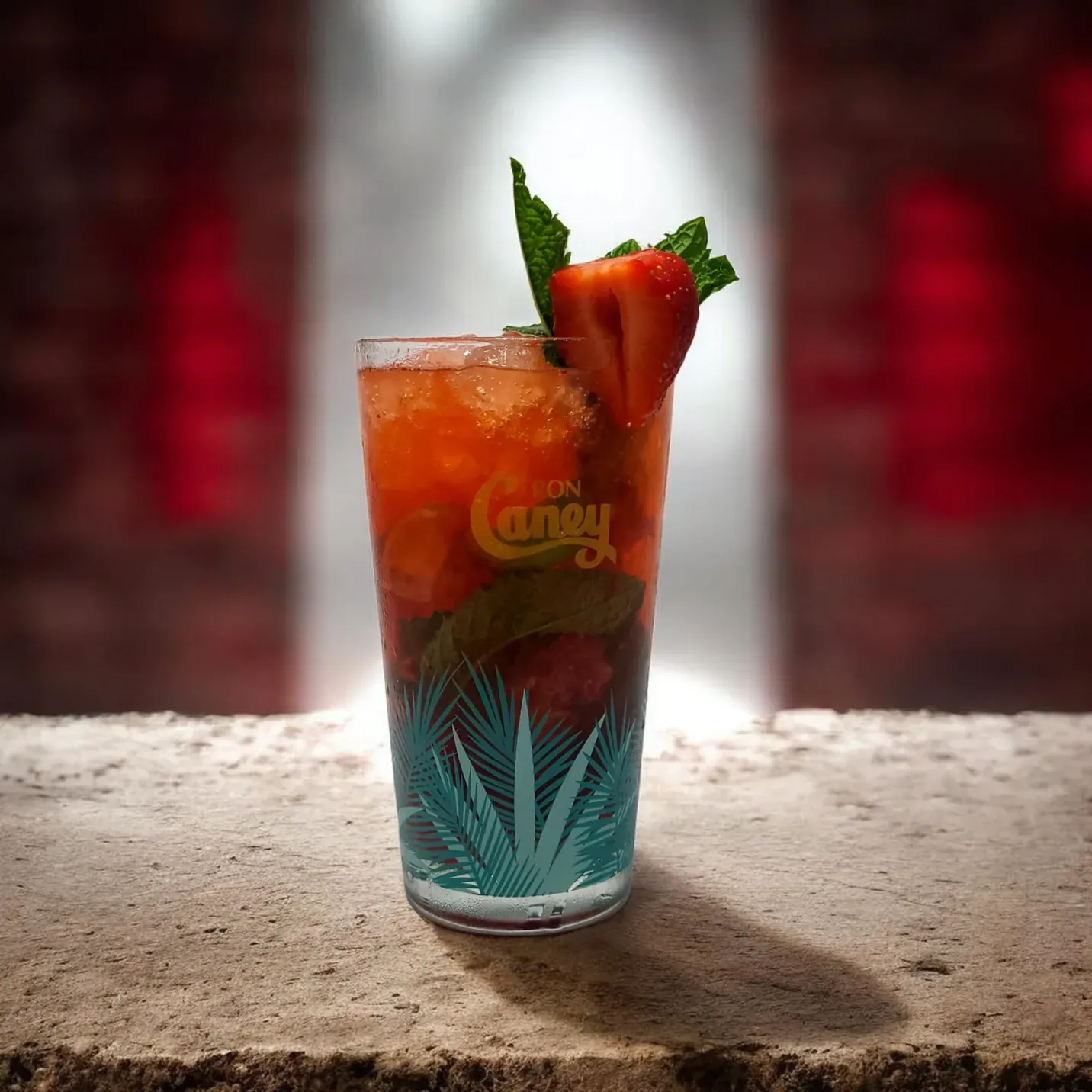 Un vaso lleno de un líquido rojo y una gelatina pálida con aspecto de cerebro, coronado con una araña de juguete negra