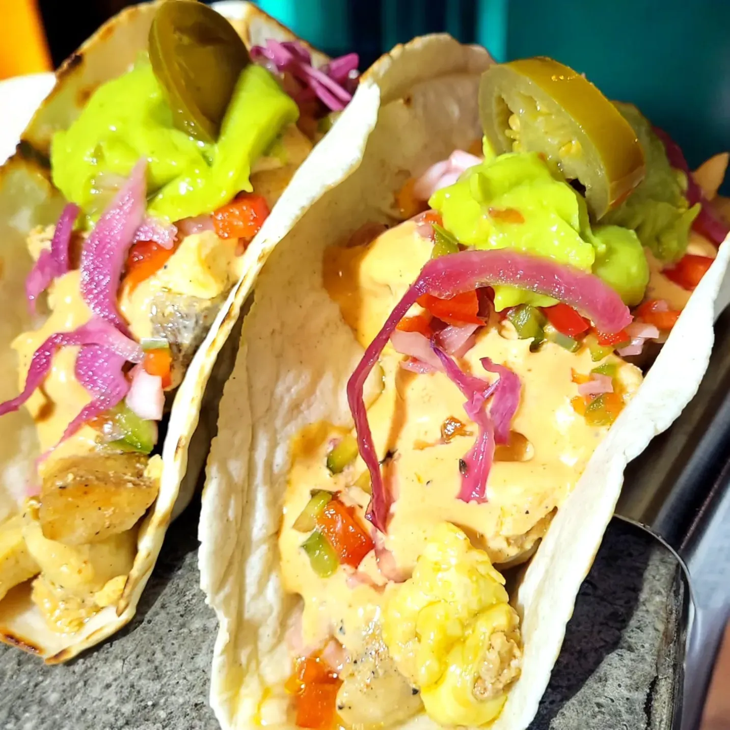 Una botella de ron Ron Caney reposa sobre una barra de madera en un restaurante, marcada con garabatos y líneas roja
