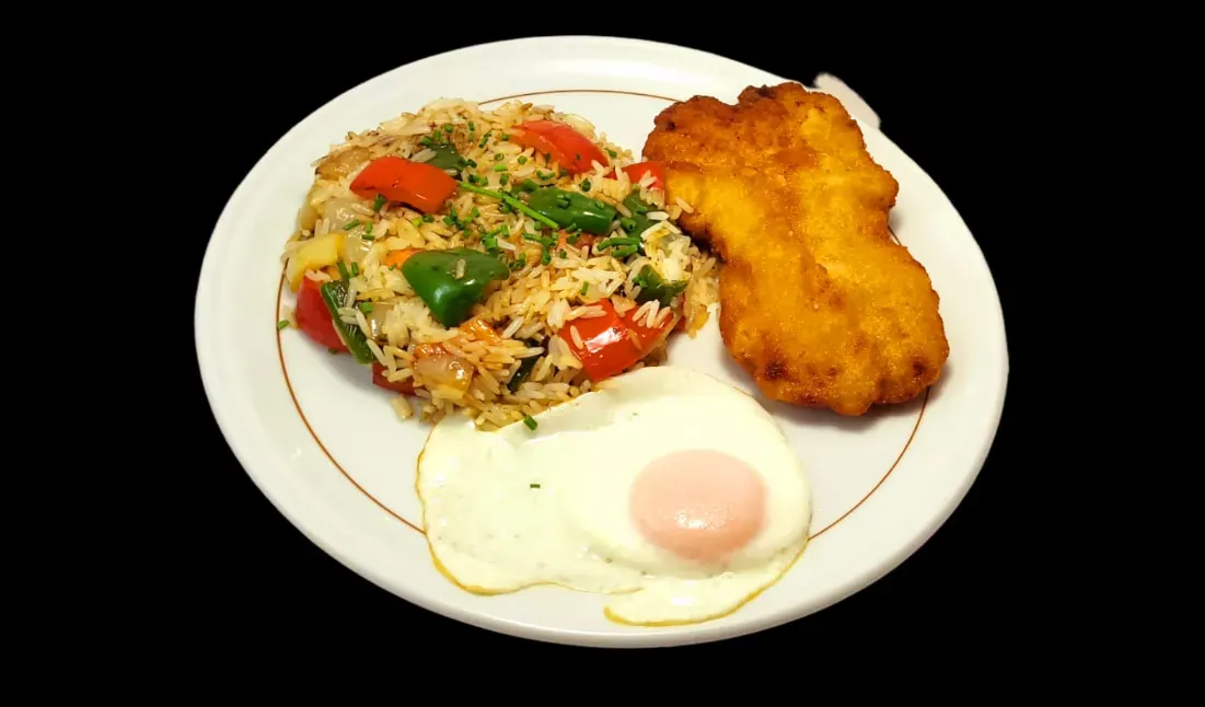 Un plato que incluye arroz frito con pimientos, un trozo de pollo frito empanizado y dorado, y un huevo frito con la yema líquida.