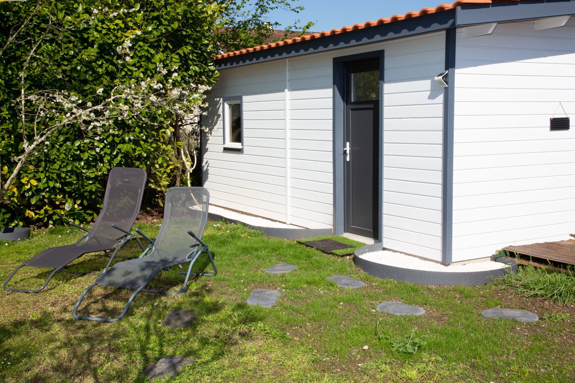 Dépendance de maison avec bardage en bois blanc