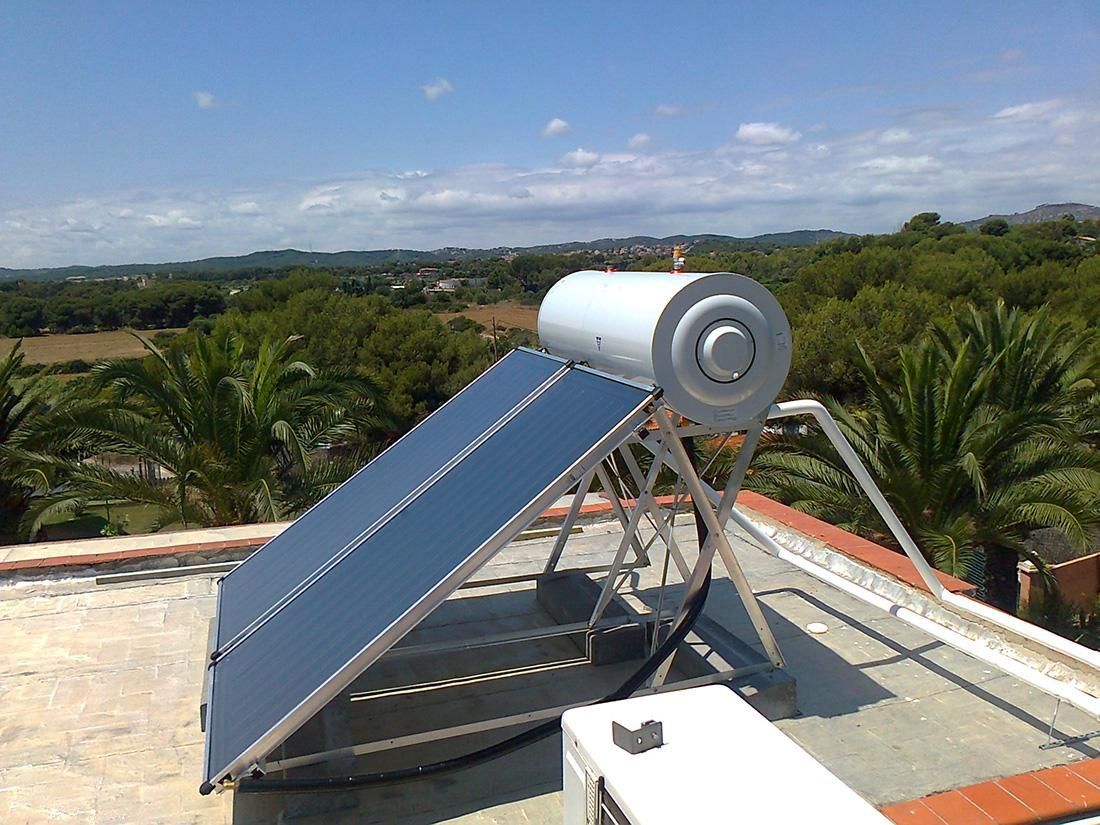 Dos paneles solares instalados en un tejado blanco bajo un cielo despejado