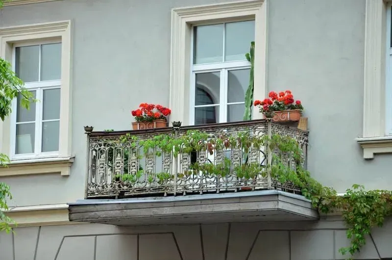 Uma cozinha com bancadas de granito, armários brancos, pisos de madeira e bancos.