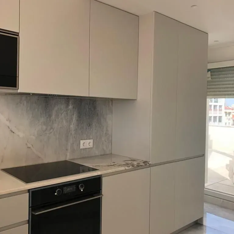 Uma cozinha com armários brancos e um fogão preto.