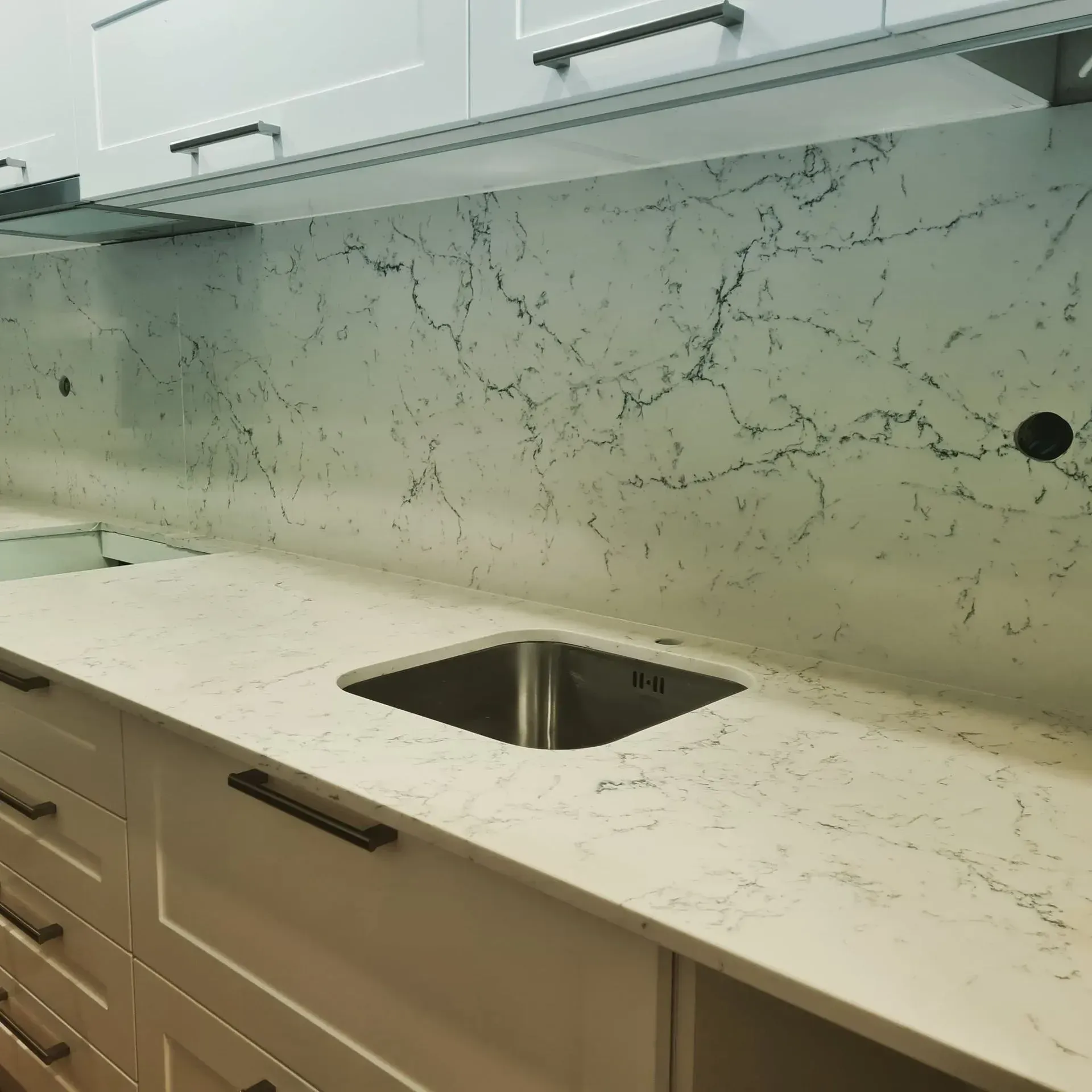 Uma cozinha com bancadas de mármore e uma pia