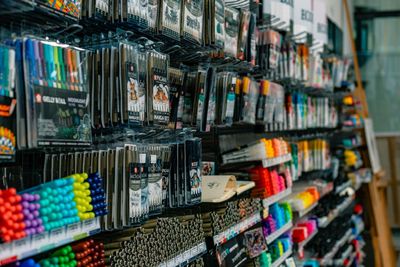 Hyllyt täynnä erilaisia ​​värikkäitä taidetarvikkeita ja kyniä vähittäismyymälässä.