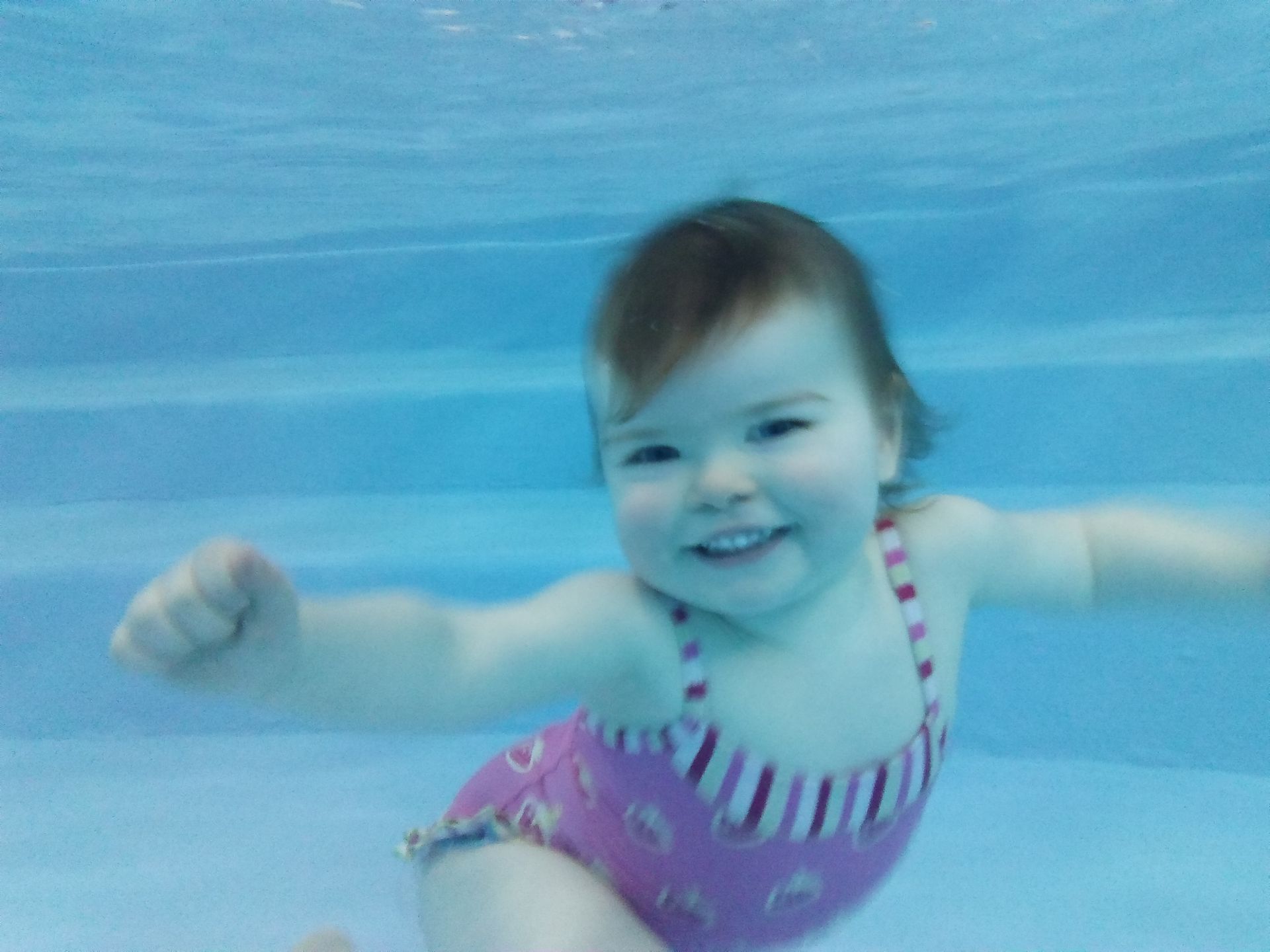 Bébé avec maillot de bain rose sous l'eau