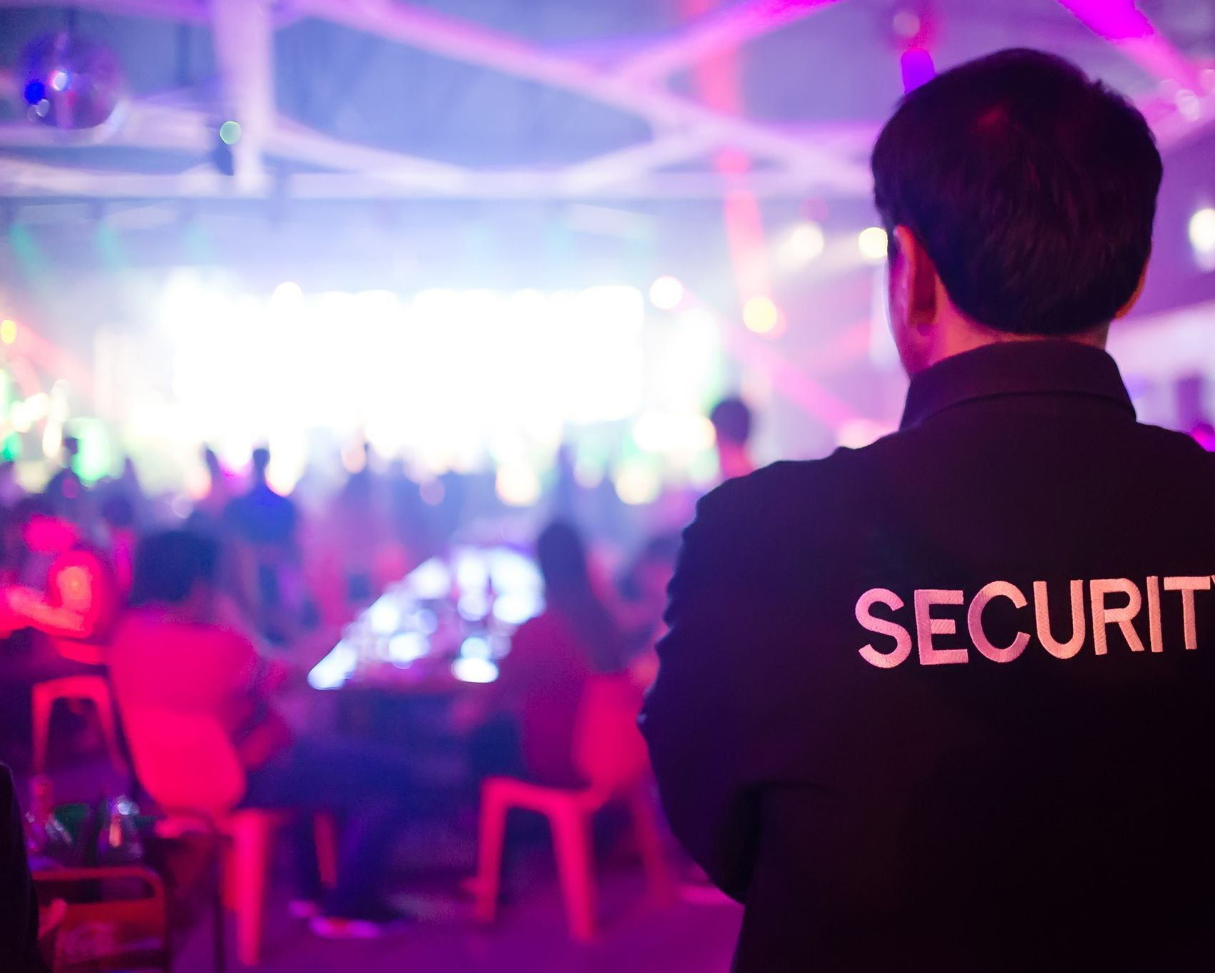 Agent de sécurité de dos qui surveille un événement