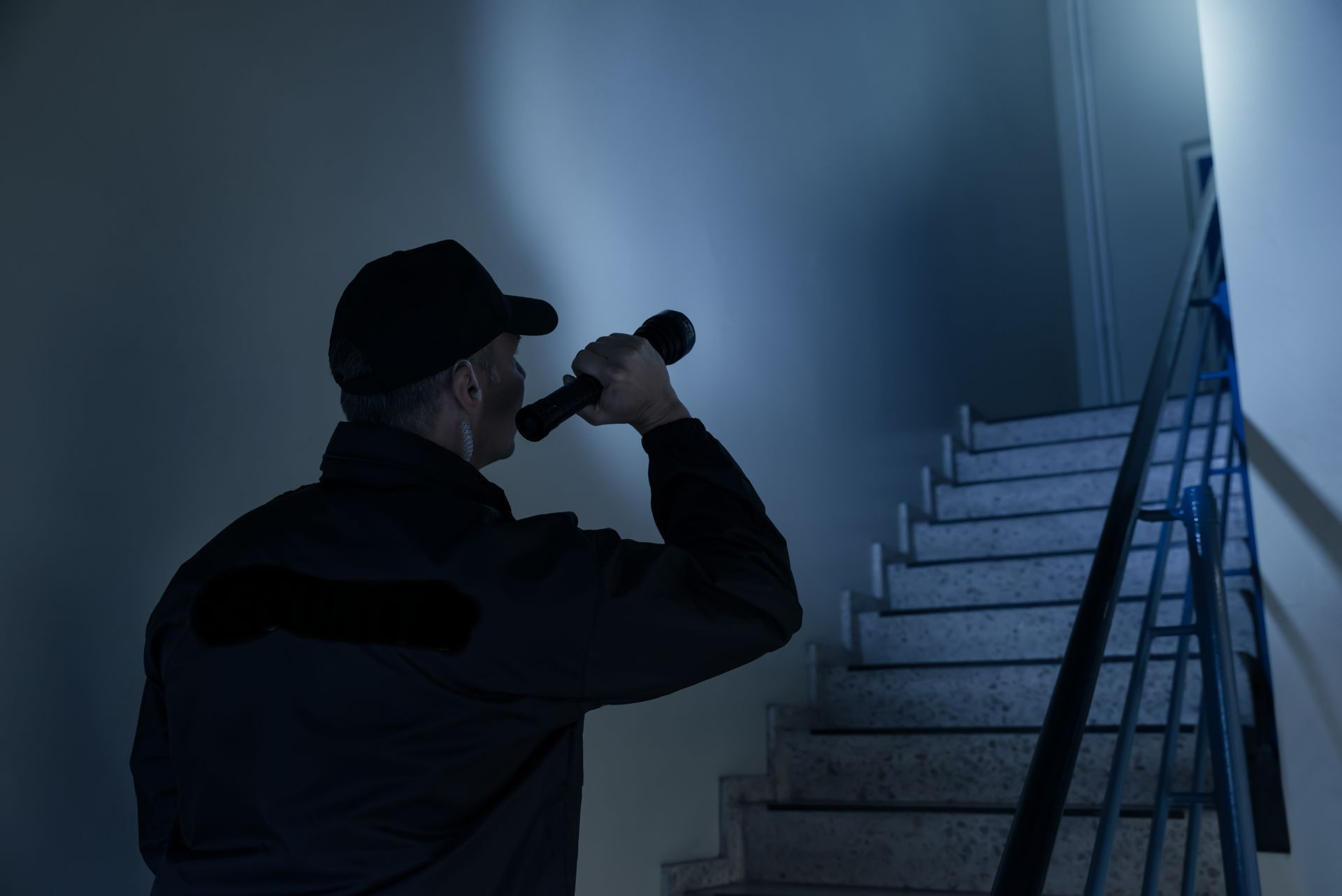 Un agent de sécurité avec une lampe torche à la main