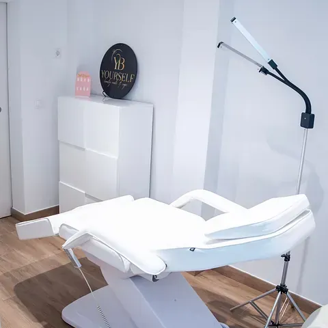 Una silla blanca está en una habitación junto a un cartel que dice