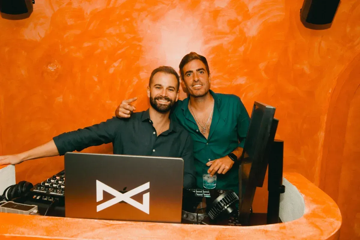 Fotografía en blanco y negro de una persona con los brazos en alto en un club abarrotado.