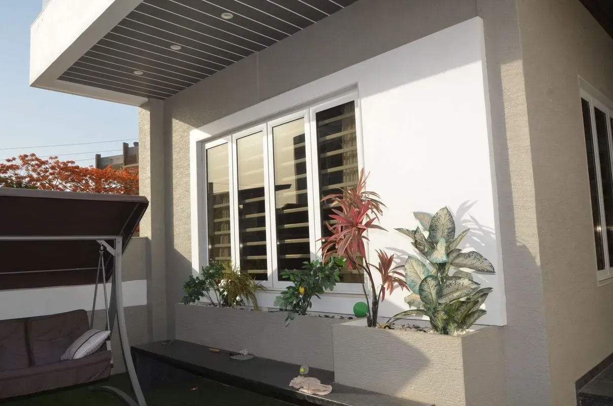 Extérieur d’une maison moderne avec une fenêtre sur mesure.