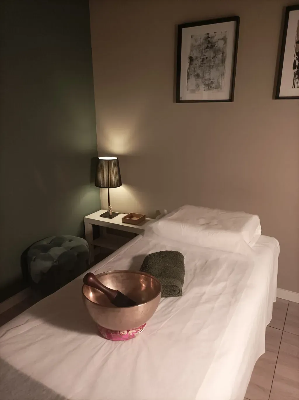 Una mesa de masaje con un cuenco encima en una habitación.