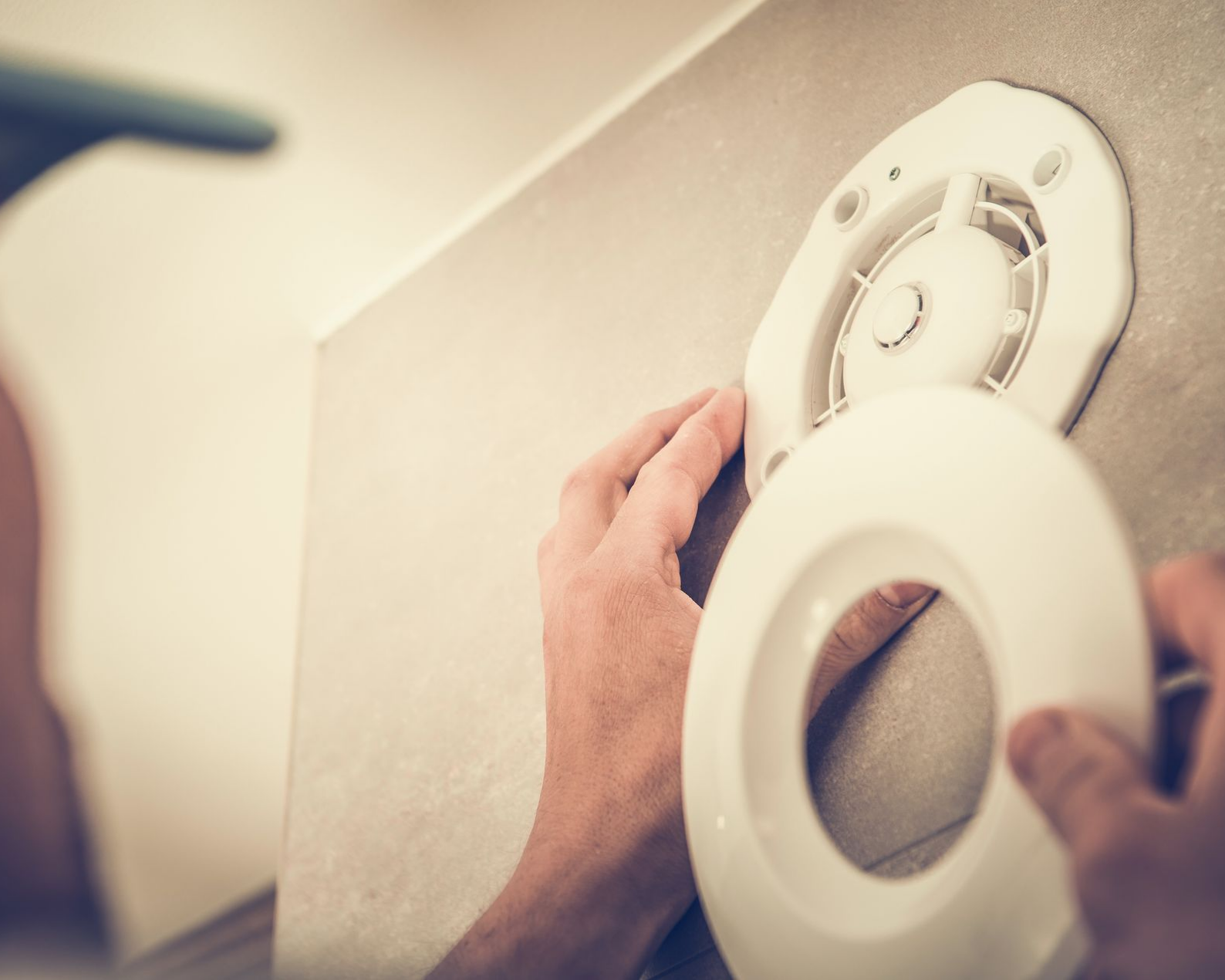 Une personne en train d’installer un système de ventilation.
