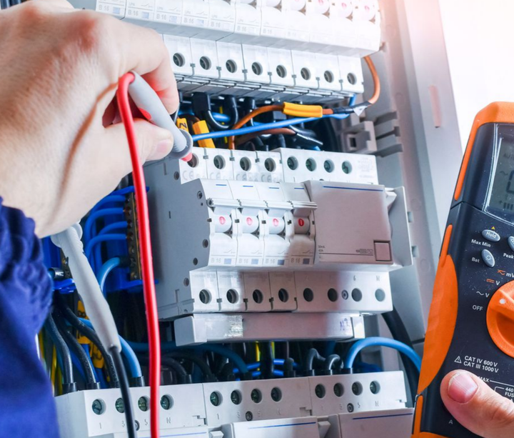 Une personne en train de vérifier un tableau électrique.