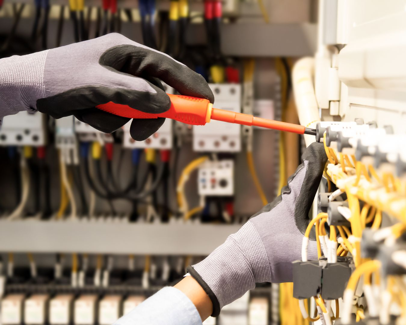 Un électricien réparant un tableau électrique.