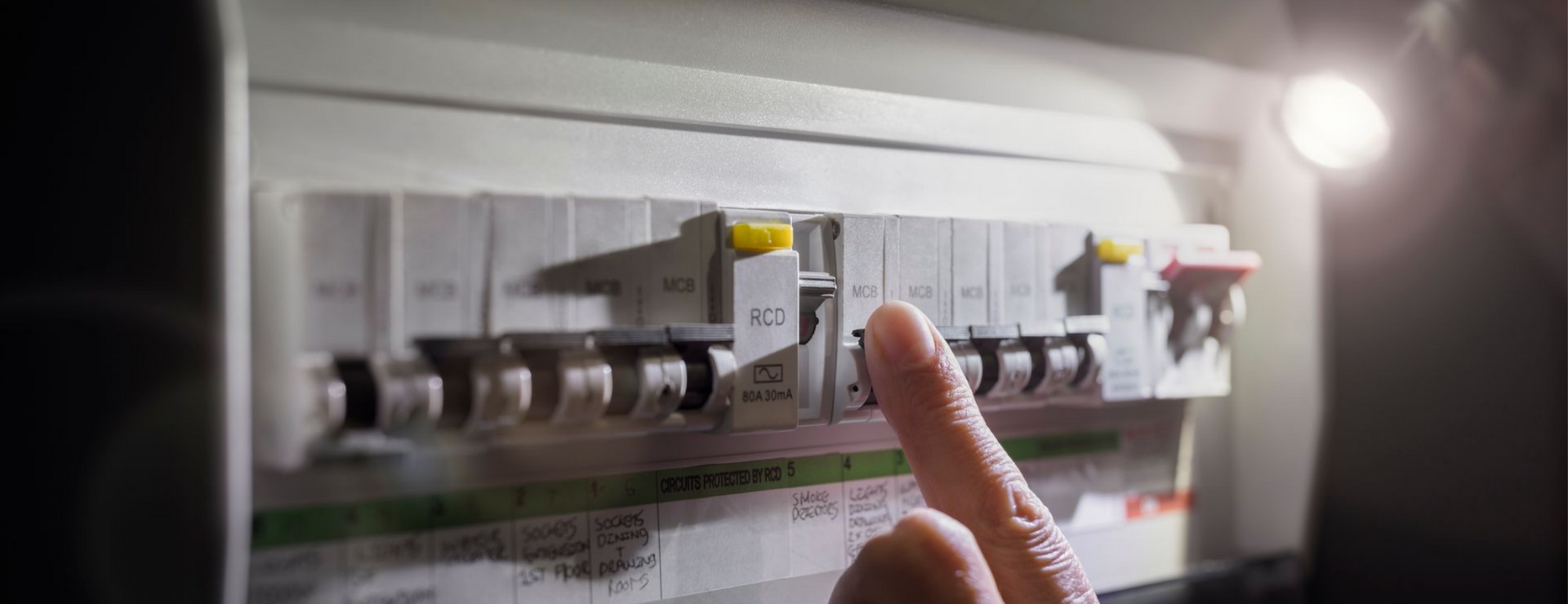 Une personne enclenchant un disjoncteur.